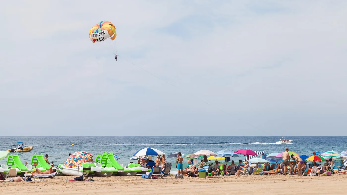 Bred sandstrand med turkost vatten och bergsmassiv på Costa Blanca — foto: ToniDlaCala